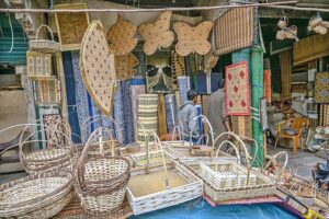 A vendor displaying handmade items to attract the customers in his shop at Saddar