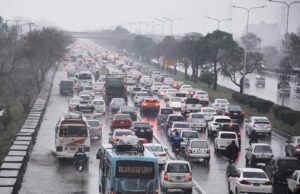 Vehicles passing through rain water accumulated on road at Ghori Town.