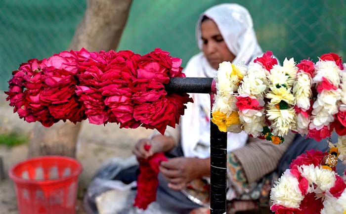 A woman making garland to attract customers at Lakeview Park in the Federal Capital.