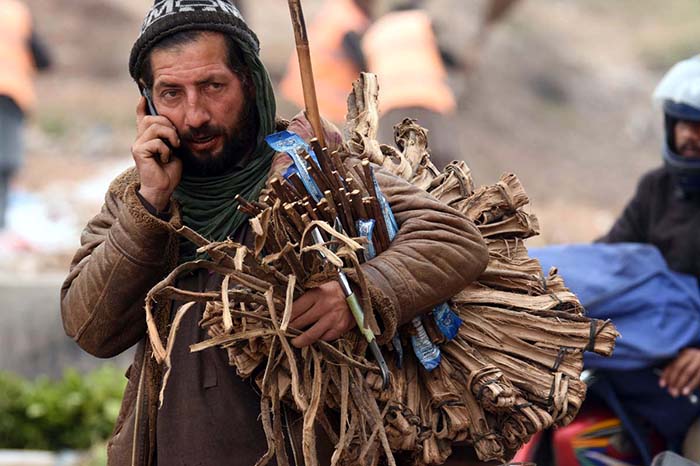 A street vendor looking for customers to sell traditional teeth cleaning stuff at Khanna Pul