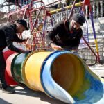 Workers Busy repairing slide Swing at Roadside Setup at Saidpur Road.