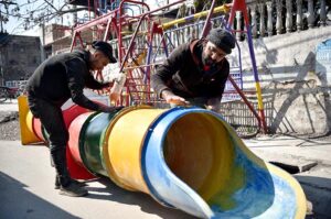 Workers Busy repairing slide Swing at Roadside Setup at Saidpur Road.