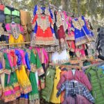 A vendor displaying traditional children clothes to attract the customers at City Road.
