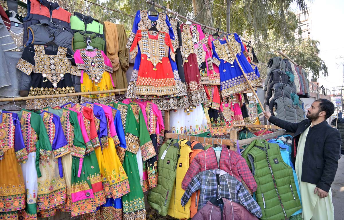 A vendor displaying traditional children clothes to attract the customers at City Road.