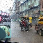 A view of rain drops on windscreen of vehicle during light rain in the city during morning time