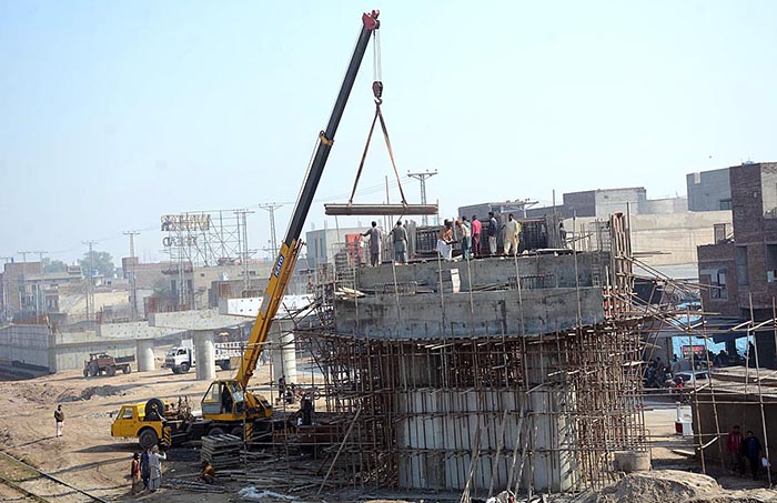 Labourers busy in construction of Abdullah Pur Jhumra Road Flyover during development work in the city.