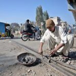 A railway worker clearing railway track to avoid any mishap.