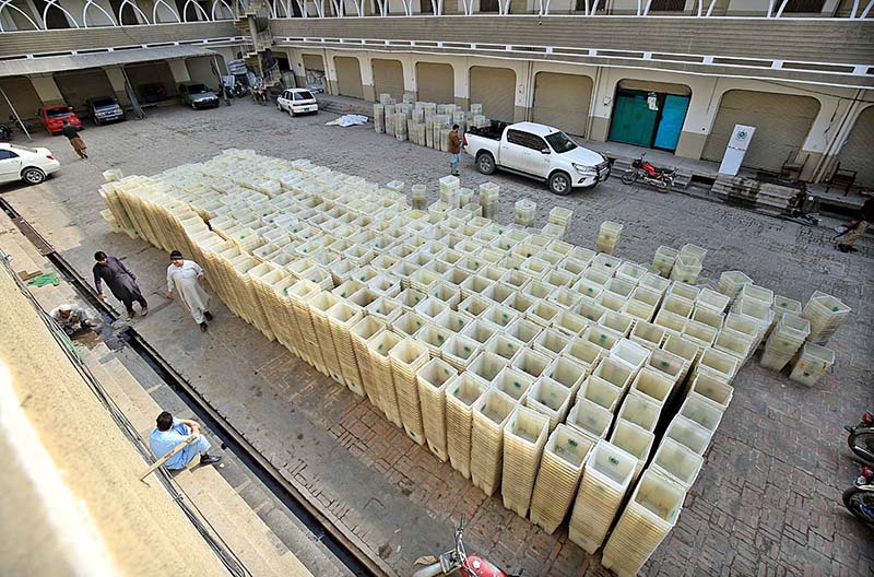 Workers of the Election Commission Office sorting ballot boxes to be sent to polling stations for the upcoming General Elections-2024 at office of the Election Commission, Kohat Road