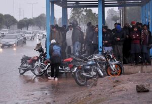 Vehicles passing through rain water accumulated on road at Ghori Town.