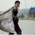 Gypsy boy on his way carrying garbage bag at Muhammad Baksh Road in the Federal Capital.
