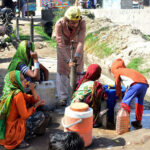 People filling their pots with clean water from hand pump at Hatri area.