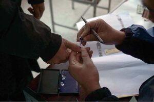 Polling officers searching the name of voter in voter’s list in the polling station during General Election-2024