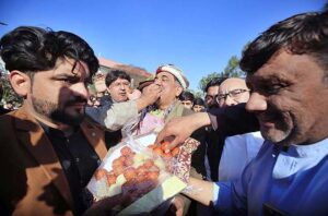 Supporters of independent candidate from PK-82, Peshawar-II, Malik Tariq Awan offering sweets to celebrate his victory in the General Election according to unofficial result.
