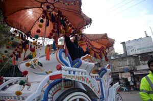 A man busy in decorating a horse-driven carriage at Committee Chowk.