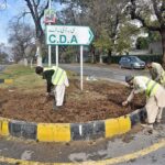 CDA workers busy in preparing center path of road for plantation in the Federal Capital.