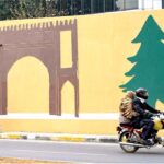 A skilled person paints the wall of 7th Avenue underpass near Aabpara Market