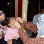 A lady health worker is administering Polio drops to a child during 7 days Anti Polio Campaign in the city.
