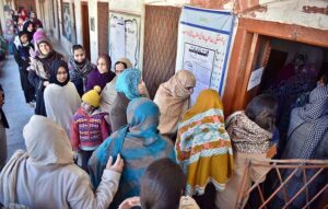 A woman casts her vote at a polling station during General Elections-2024.