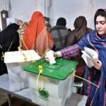 A woman casts her vote at a polling station during General Elections-2024.