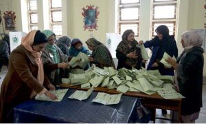 Polling official opens ballot box to count votes at a polling station in F-6 area during General Elections-2024.