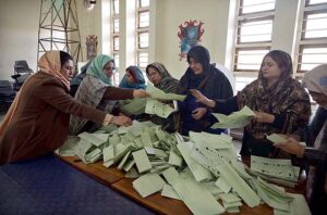Polling official opens ballot box to count votes at a polling station in F-6 area during General Elections-2024.