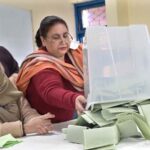 Polling official opens ballot box to count votes at a polling station in F-6 area during General Elections-2024.