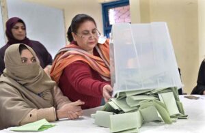 Polling official opens ballot box to count votes at a polling station in F-6 area during General Elections-2024.