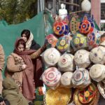 A woman purchases handmade baskets from a roadside vendor at Rahmanabad