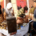 Woman artist making clay made items on her stall during Faiz Mela at Al-Hamra