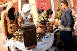 Woman artist making clay made items on her stall during Faiz Mela at Al-Hamra
