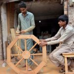 A carpenter busy in finishing wooden item at his workplace.