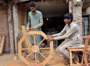A carpenter busy in finishing wooden item at his workplace.