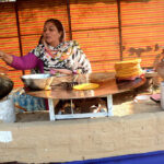 A woman vendor busy making traditional bread (Paratha) at Jilani Park.