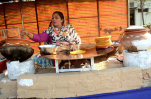 A  woman vendor busy making traditional bread (Paratha) at Jilani Park.
