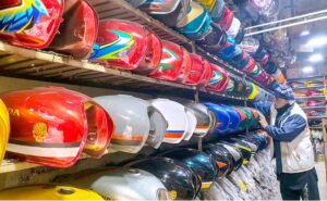 A shopkeeper displays motorcycle’s fuel tanks to attract the customers at his display center