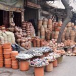 Shopkeepers displaying clay-made pots to attract customers in front of their shop