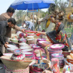 Woman vendor displaying and selling handmade household items to earn a livelihood at roadside setup