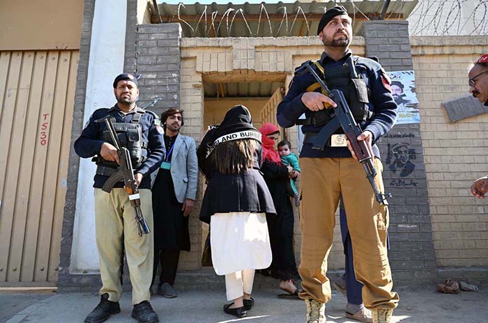 A security personnel standing alert outside a polling station during General Election-2024.