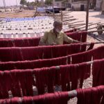A labourer arranging threads for dry purpose outside Threads factory.