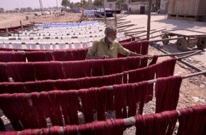  A labourer arranging threads for dry purpose outside Threads factory.