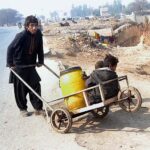 A gypsy youngster on his way back while pushing handcart after filling clean drinking water