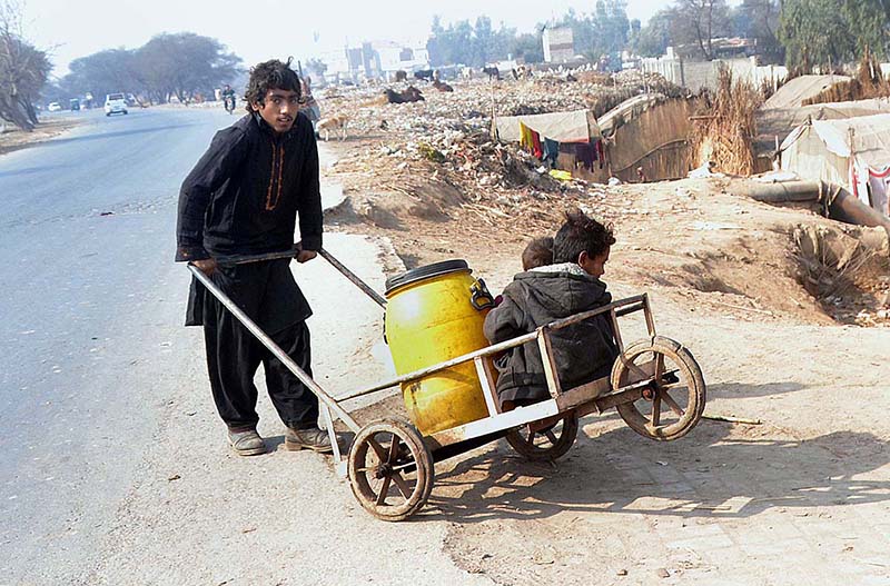 A gypsy youngster on his way back while pushing handcart after filling clean drinking water