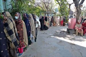 People standing in queue in front of polling station to cast their vote during General Election-2024