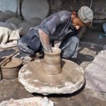 Craftsmen busy in preparing clay made pots at his workplace.