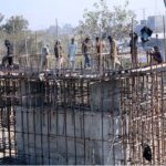 Labourers busy in construction of Abdullah Pur Jhumra Road Flyover during development work in the city.