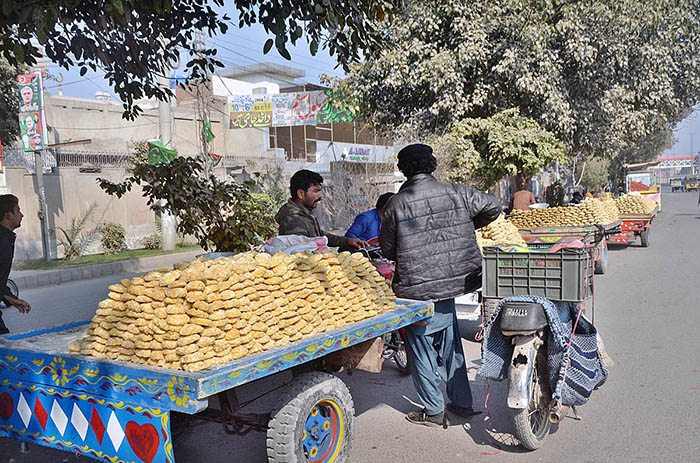 Vendors displaying sweet item (gur) to attract the customers at General Bus Stand Road.