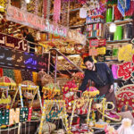 A vendor displaying the different kinds of decorative stuff using during marriage ceremonies at his workplace.