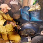 A worker busy in roasting grams for customers at his workplace