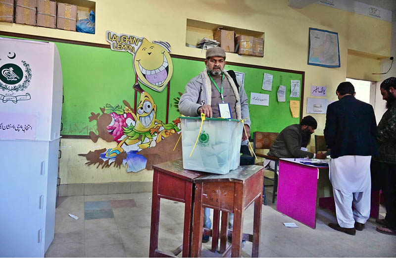 A voter casts his vote in ballot box at a polling station during General Elections
