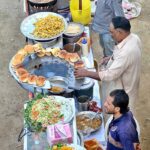Vendors displaying the traditional food items chips and Burgers to attract the customers outside road at Latifabad.